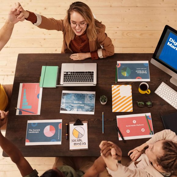 Colleagues celebrating success in a modern digital marketing office with teamwork and collaboration.